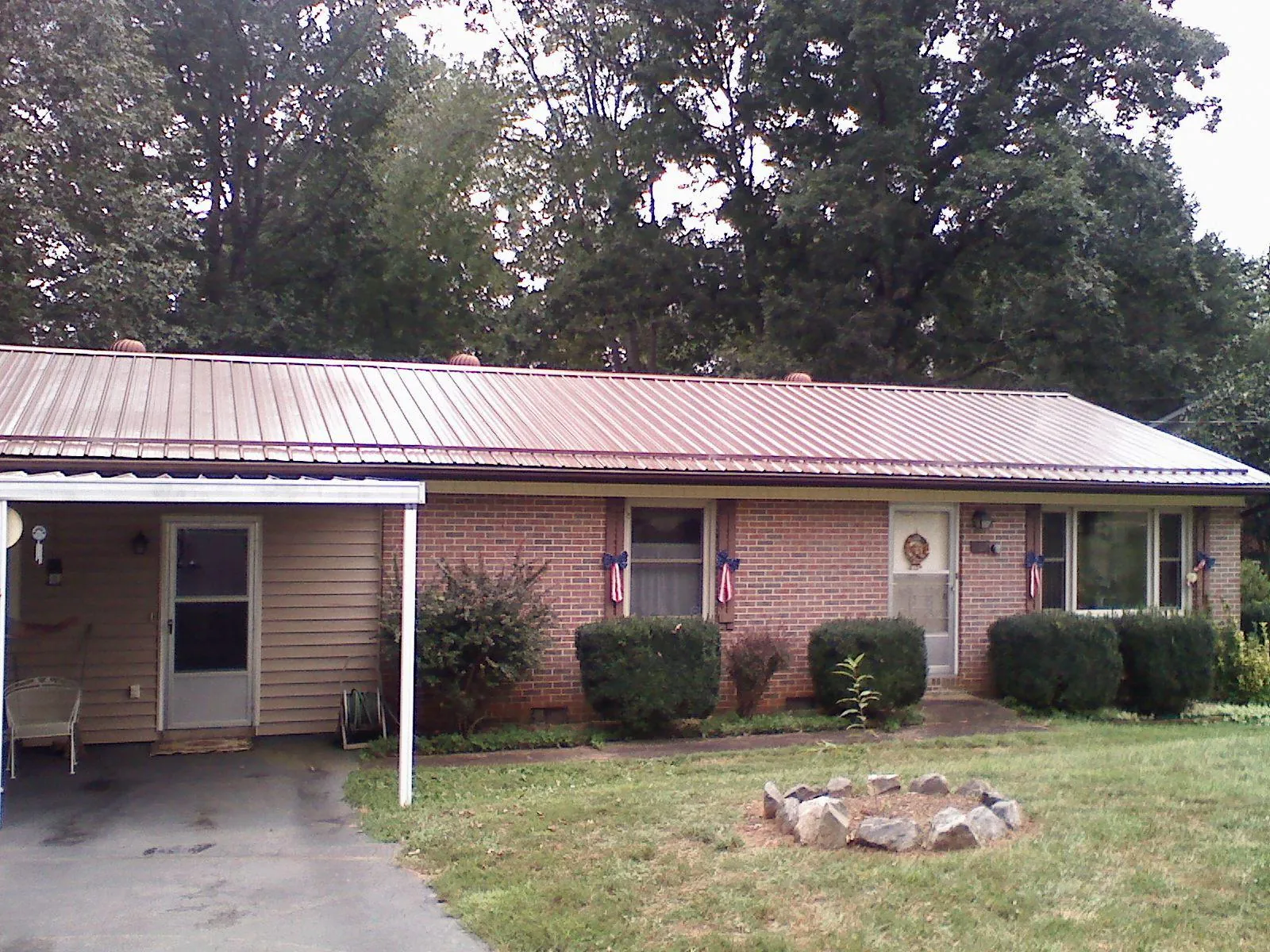 Bronze metal roof and carport on a brick ranch home — Roof Repair work by our crew in Fort George G Meade